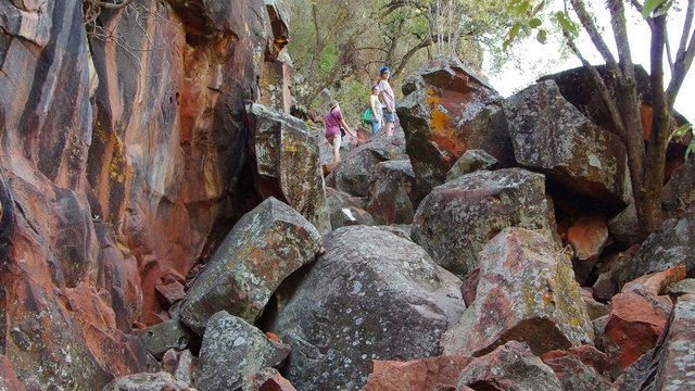 Drei Menschen klettern über die Felsformationen am Waterberg