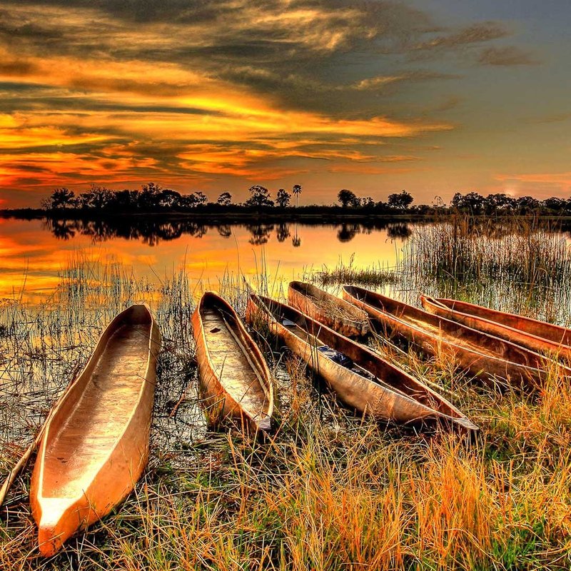 Mokoros im Sonnenuntergang am Ufer des Okavango