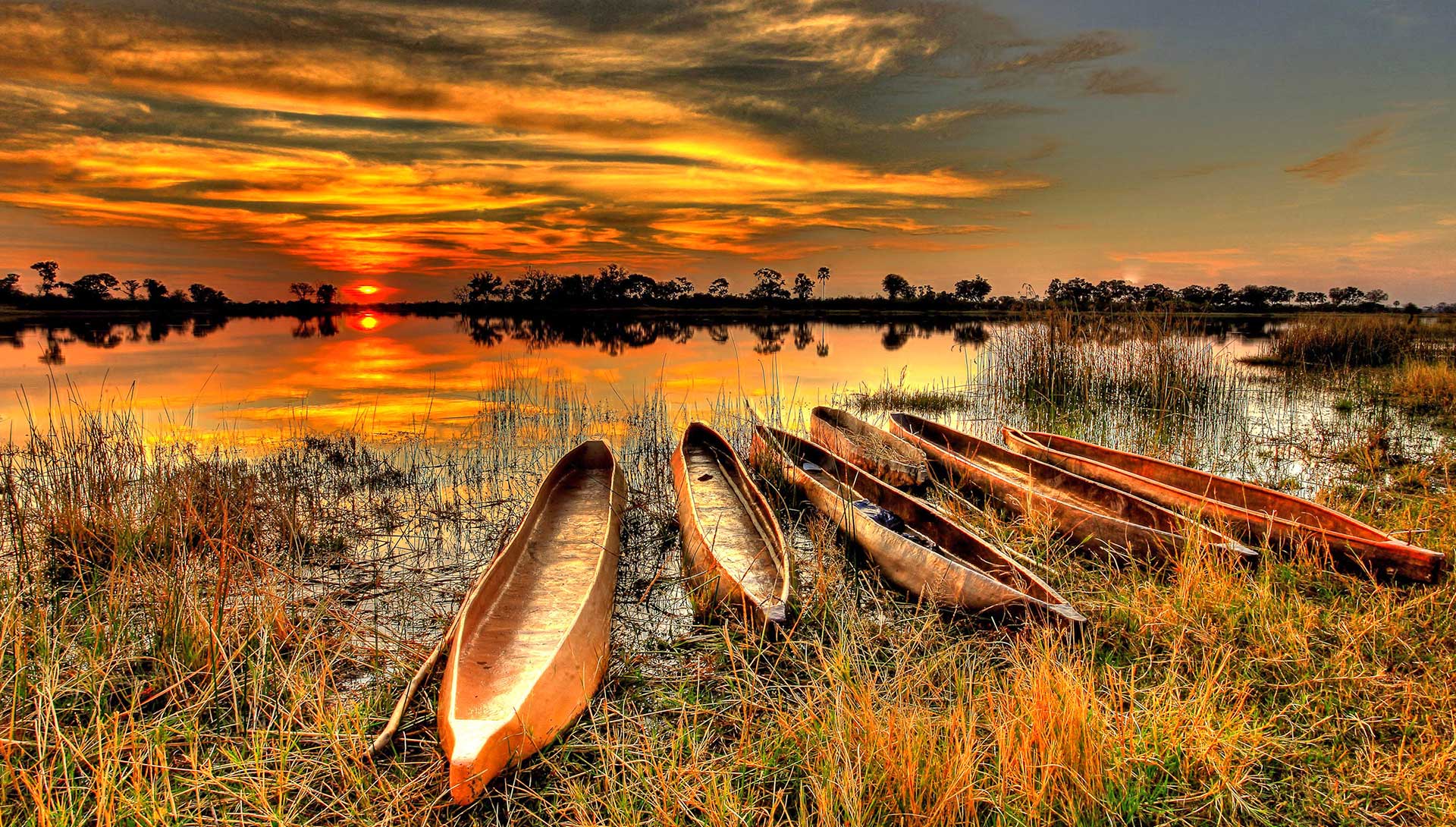 Mokoros im Sonnenuntergang am Ufer des Okavango